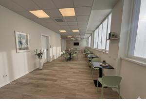 a long hallway with tables and chairs and windows at SPACE101 City Apartment & Studio in Limito di Pioltello
