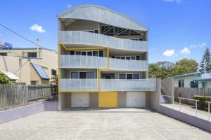a building with a yellow and white garage at Above The Dunes in Woorim