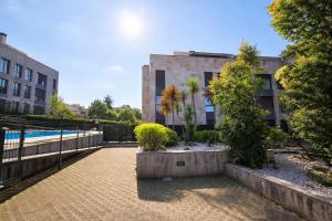 a courtyard with a pool and a building at El Ático de Celorio – Piscina, Terraza y Playa in Celorio