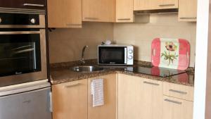 a kitchen with a sink and a microwave at El Ático de Celorio – Piscina, Terraza y Playa in Celorio +23 photos