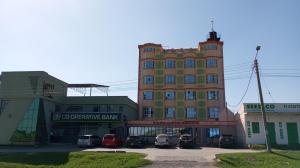 a large building with cars parked in a parking lot at Tour Gate Hotel in Naro Moru