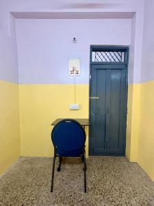 a blue chair sitting in front of a desk next to a door at Urban Mansion Triplicane in Chennai