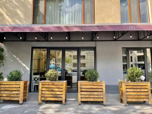 a restaurant with two wooden benches in front of it at Merien hotel in Yerevan