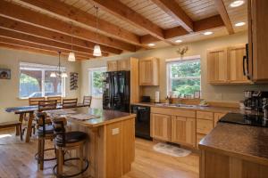 a kitchen with wooden cabinets and a black refrigerator at Paws in the Mountains by NW Comfy Cabins in Leavenworth