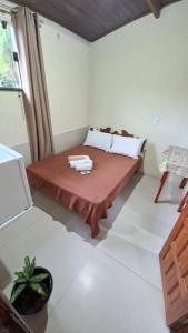 a room with a bed and a table in it at Pousada Iasbeck in Santa Rita de Jacutinga
