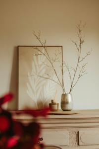 a vase sitting on top of a dresser with a plant at De Dommelhoeve in Peer