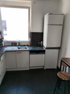 a kitchen with a refrigerator and a sink and a window at Marie Zimmer Zentral Bequem in Heilbronn