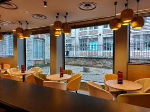 a restaurant with tables and chairs and a large window at ibis Besançon Centre Ville in Besançon