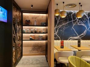 a restaurant with tables and chairs and a spiderweb wall at ibis Besançon Centre Ville in Besançon