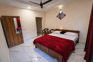 a bedroom with a large bed with a red blanket at LASplore munnar in Kallar Vattiyar