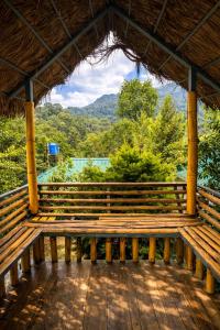a wooden bench on a porch with a view at LASplore munnar in Kallar Vattiyar