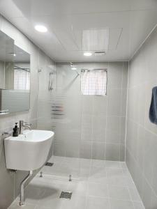 a white bathroom with a sink and a shower at Kintex Central Stay 3BR 2Bath Spacious Space in Ilsan-yŏk +22 photos