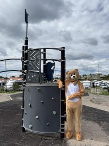 a teddy bear standing in front of a playground at GrebbestadFjorden vandrarhem in Grebbestad