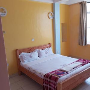 a bedroom with a bed with white sheets and a window at Tour Gate Hotel in Naro Moru +32 photos