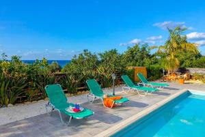 a group of chairs and a swimming pool at Villa Adonis Large Private Pool Walk to Beach in Argaka