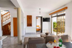 a living room with a couch and a table at Villa Adonis Large Private Pool Walk to Beach in Argaka