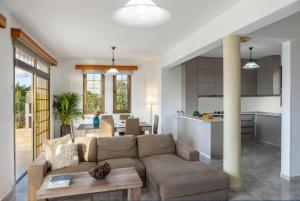 a living room and kitchen with a couch and a table at Villa Adonis Large Private Pool Walk to Beach in Argaka
