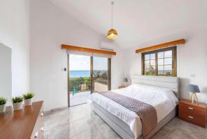 a bedroom with a large bed and a large window at Villa Adonis Large Private Pool Walk to Beach in Argaka +31 photos