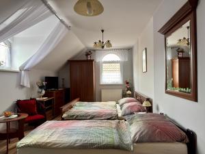 a bedroom with two beds and a mirror at Penzion U Kapličky in Malá Hraštice