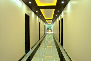 an empty hallway with a long corridor with lights at Hotel vasurai and restaurant in Nākuri