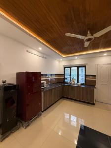 a large room with a kitchen with a ceiling at Sunrise Rest House in Islamabad