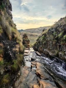a river in the middle of a rocky mountain at Uitvlugt Ponds in Dullstroom