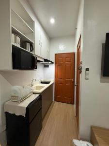 a small kitchen with a sink and a microwave at E&J Solace Studio Mactan Bayanihan Flats 2 in Maribago