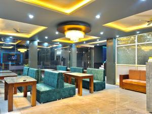 a lobby with chairs and tables and a chandelier at Hotel vasurai and restaurant in Nākuri