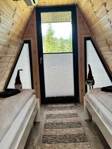 two beds in a room with two windows at 3A-CHALET-LIBaN in Liban