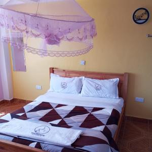 a bedroom with a bed with white sheets and a window at Tour Gate Hotel in Naro Moru