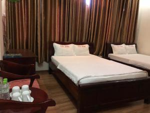 a hotel room with two beds and a table with a table at namhan in Phú Quốc