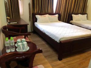 a room with two beds and a table with bottles of water at namhan in Phú Quốc