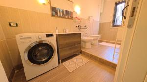 a bathroom with a washing machine and a toilet at La Costa del Pavone in Carini +25 photos