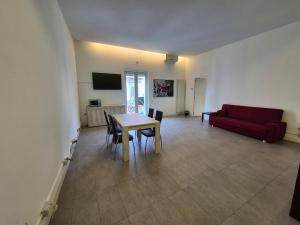 a living room with a table and a red couch at Casa Bon in Marigliano