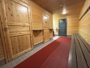 a sauna with wooden doors and a red rug at Riihen Ullakko in Äkäslompolo