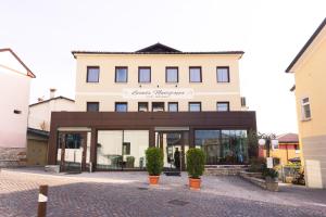 a building with a store front with windows at Locanda Montegrappa in Borso del Grappa