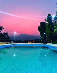 a swimming pool with a sunset in the background at West wind Resort in Meppādi +9 photos