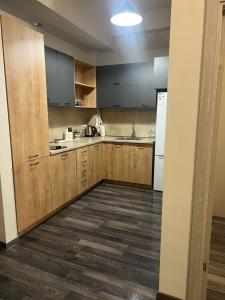 a kitchen with wooden cabinets and a white refrigerator at Kechi House Jaklin in Tsaghkadzor