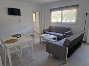 a living room with a couch and a table at Playa Son Moll in Cala Ratjada