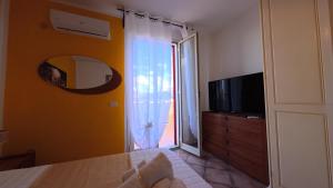 a room with a tv and a sliding glass door at La Costa del Pavone in Carini
