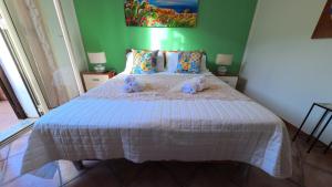 a bedroom with a bed with two stuffed animals on it at La Costa del Pavone in Carini