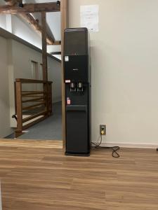 ein schwarzer Kühlschrank, der in der Ecke eines Zimmers steht in der Unterkunft Lodges大黒 in Toyama