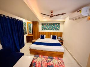 a bedroom with a bed with blue pillows at Hotel Shree Darshan - Near Mahakal Mandir Ujjain in Ujjain