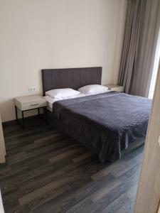 a bedroom with a bed and a wooden floor at Kechi House Jaklin in Tsaghkadzor