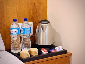 a tray with two bottles of water and a tea kettle at Hotel Shree Darshan - Near Mahakal Mandir Ujjain in Ujjain