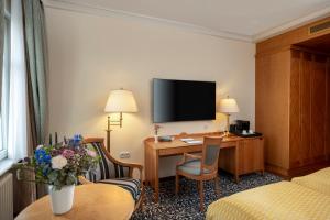 a hotel room with a desk and a room at Potsdam Hotel Am Jägertor in Potsdam +43 photos