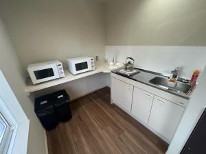 eine kleine Küche mit Spüle und zwei Mikrowellen in der Unterkunft Lodges大黒 in Toyama