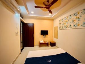 a bedroom with a bed and a ceiling fan at Hotel Shree Darshan - Near Mahakal Mandir Ujjain in Ujjain