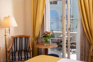 a room with a chair and a table with a vase of flowers at Potsdam Hotel Am Jägertor in Potsdam
