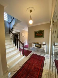 a living room with stairs and a red rug at Vinland Villa Atalar in Trabzon